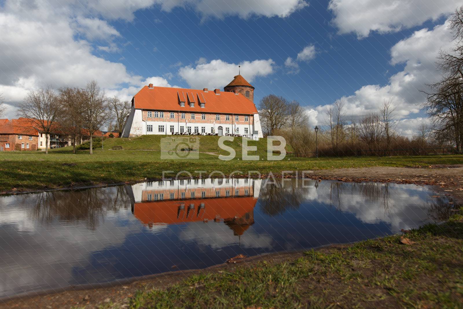 Die Neustädter Burg spiegelt sich in einer Pfütze